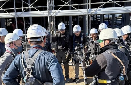 朝礼で集まるヘルメット姿のチーム